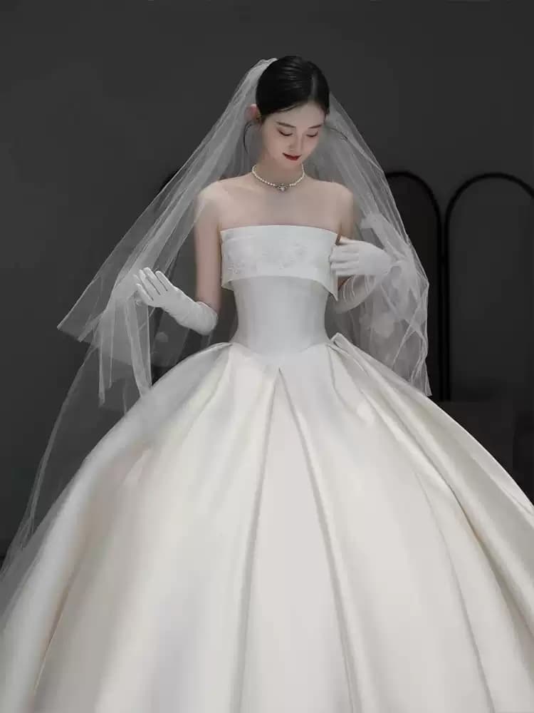 Strapless French-style light wedding gown featuring luxurious satin premium texture and a long train